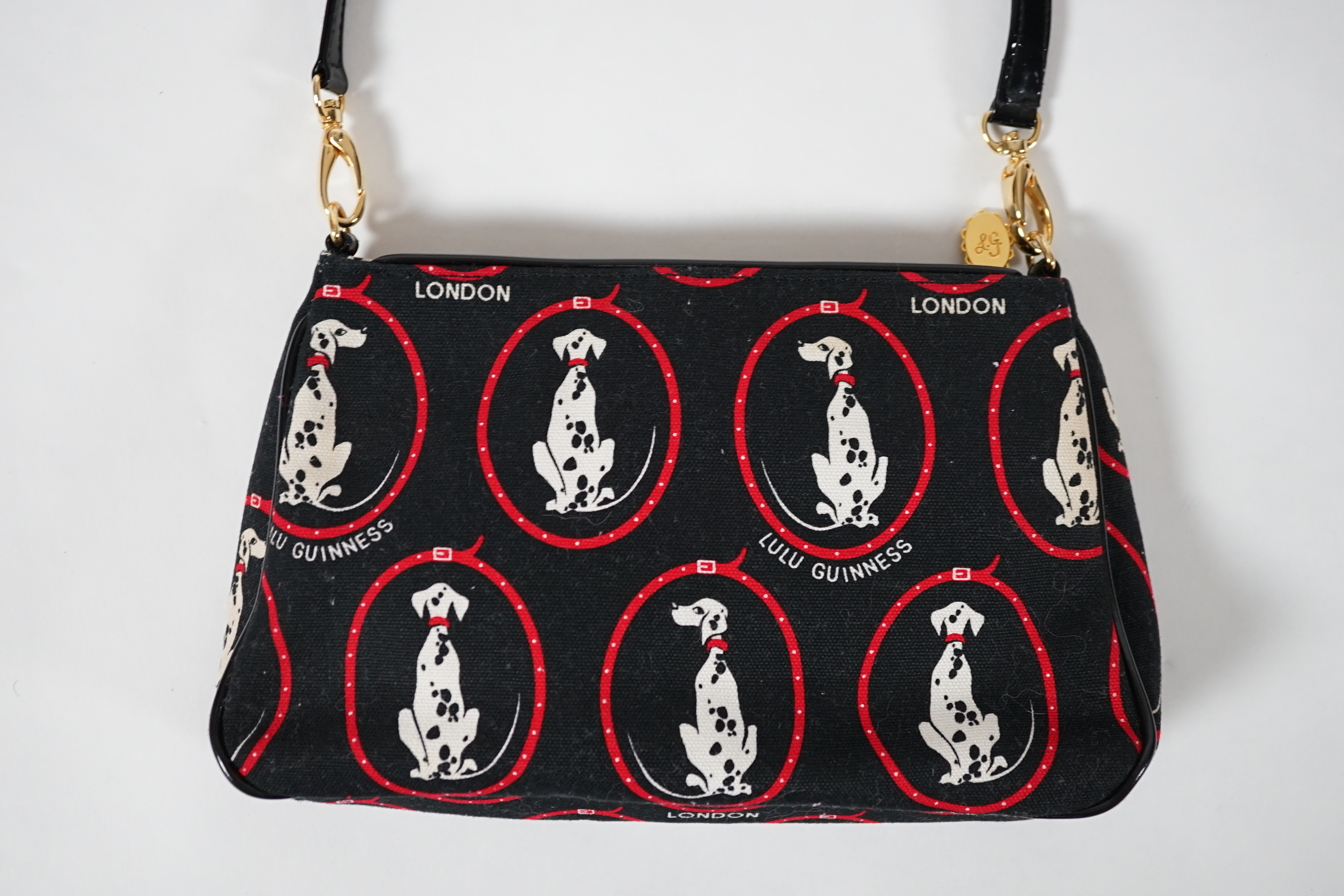 A vintage Lulu Guinness black canvas Dalmatian handbag with black patent leather strap and piping, height 15cm, height to strap 37cm, width 24cm, depth 5cm